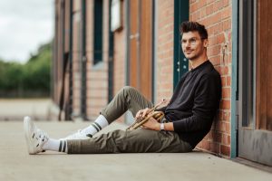 Patrick Hinsberger lehnt an Hauswand